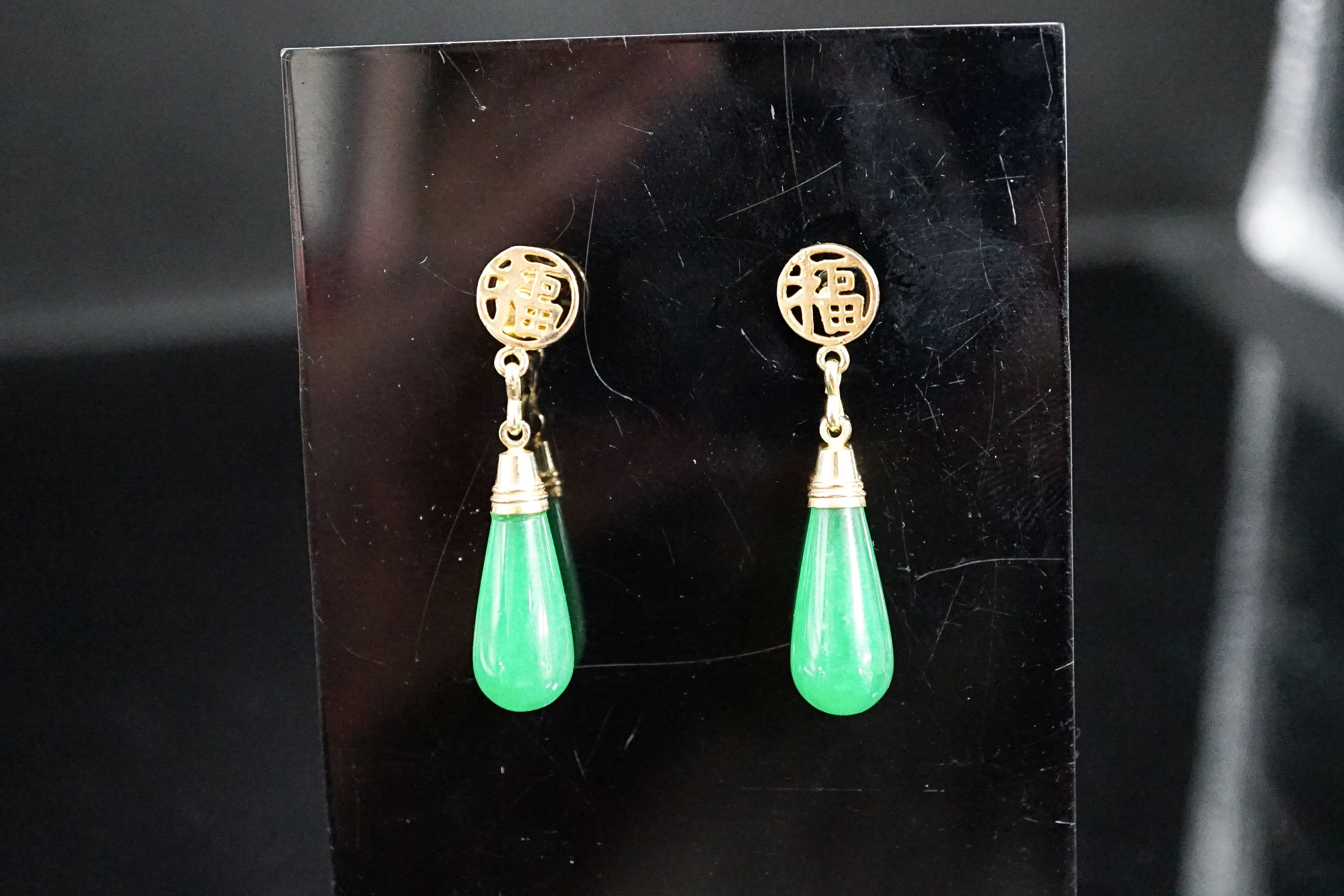 A pair of Chinese yellow metal mounted teardrop shaped jade earrings, 21mm, gross weight 5.1 grams.